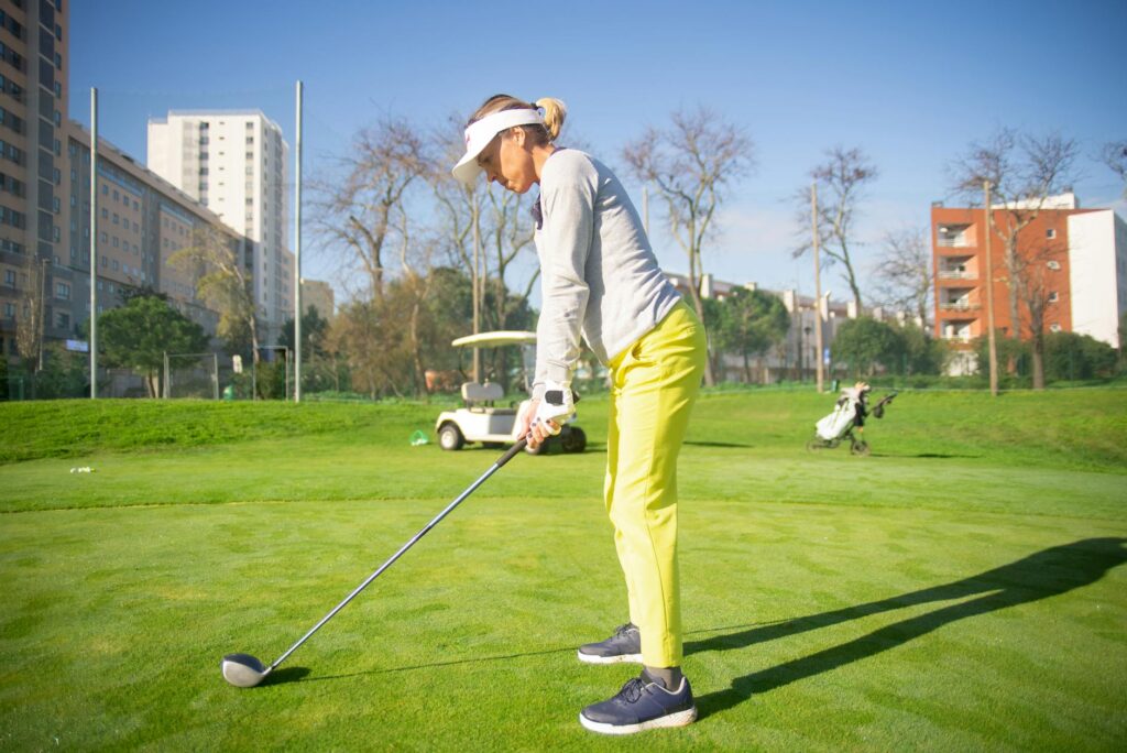 A golfer adjusting their stance on a windy day. — golf swing weather effects