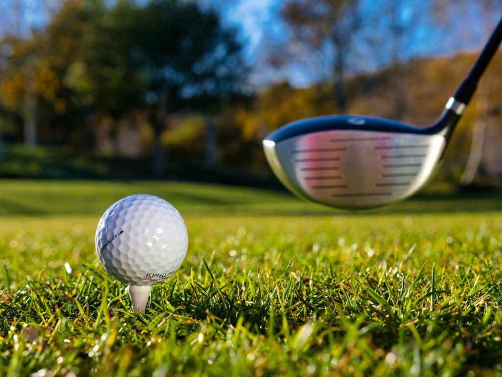 A close-up of a golf ball on a tee with a backdrop of the Dungeness landscape. — best time to play golf Dungeness