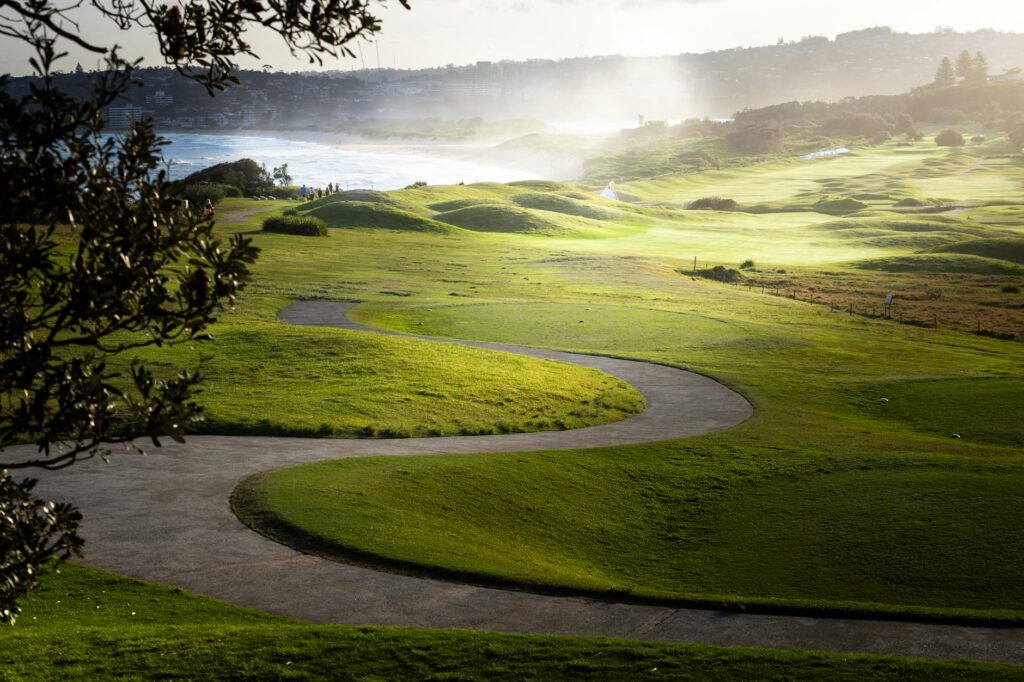 A coastal golf course with dramatic waves and strong winds in the background. — best golf courses weather conditions