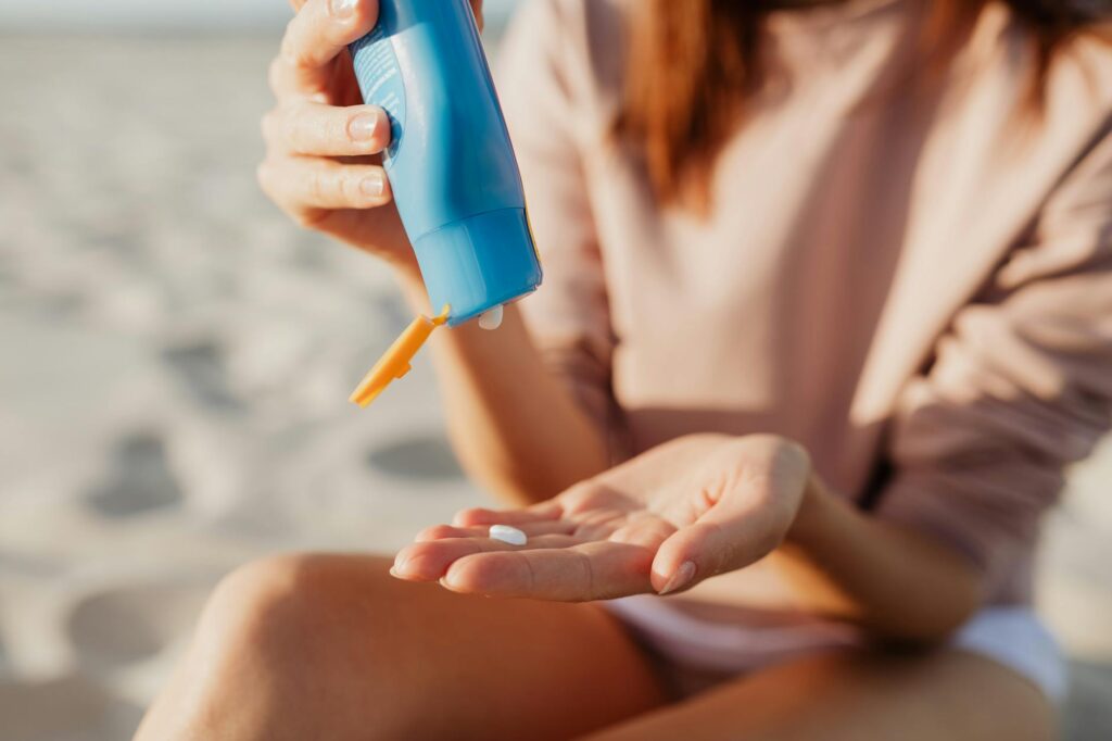 A golfer applying sunscreen on the course to demonstrate sun safety. — UV rays golf performance