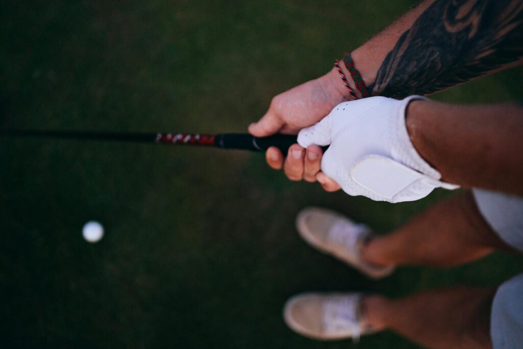 A golfer practicing their swing under humid conditions, showing the effects of sweat and grip. — humidity effects on gol…