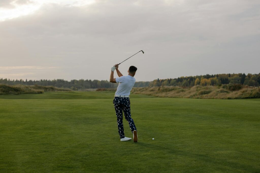 A golfer swinging a club against a backdrop of high mountains, illustrating the challenges of high altitude golf. — golf…