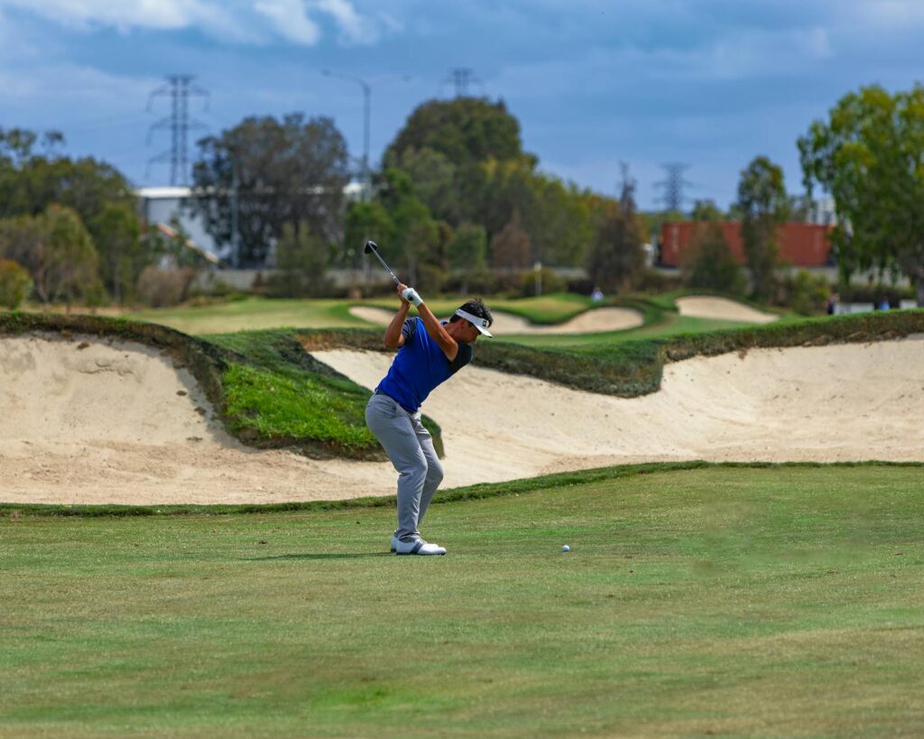 A golfer swinging on a lush Dungeness fairway. — Dungeness golf courses