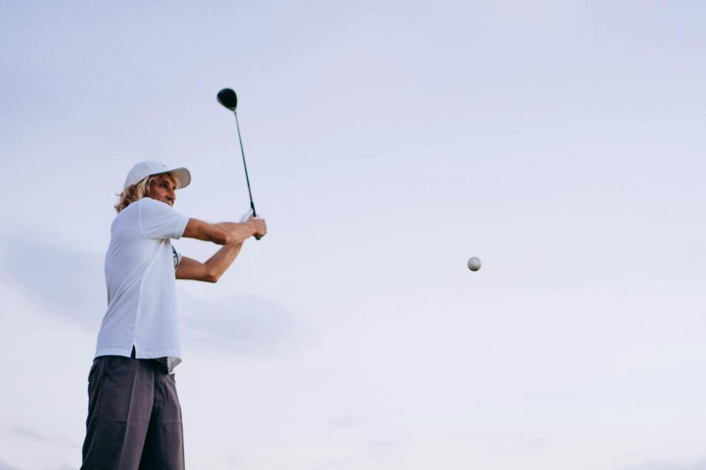 A golfer swinging under clear blue skies, highlighting ideal weather conditions. — ideal weather for golf swing
