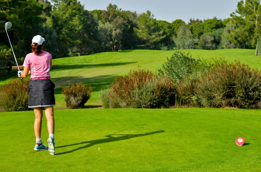 A golfer teeing off on a sunny summer day at Dungeness. — best time to visit Dungeness golf