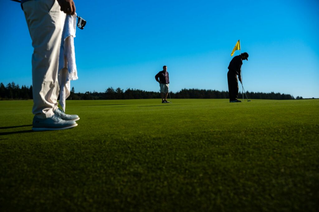A serene view of the Dungeness golf course with players in the background. — golf etiquette Dungeness