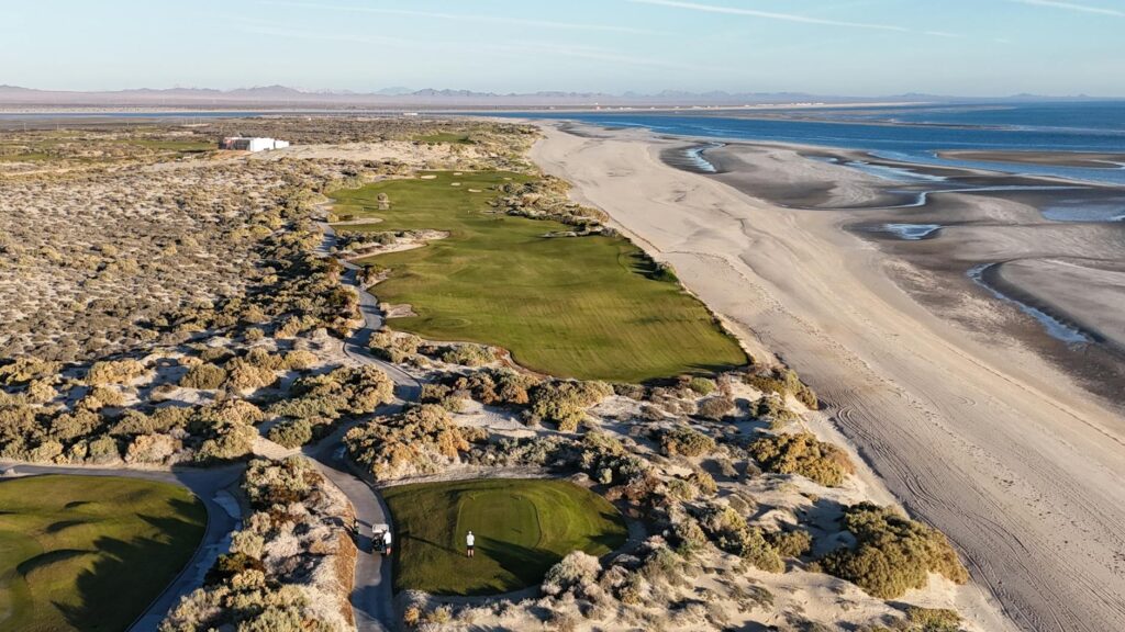 An aerial view of the Dungeness coastline and golf course during sunset. — best time to golf Dungeness