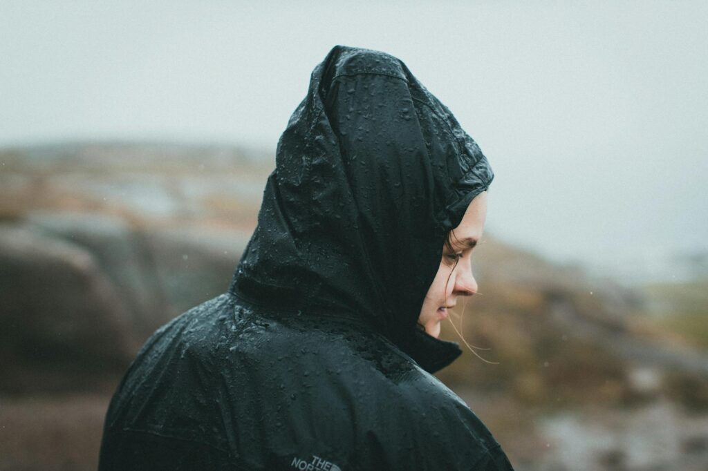 An image of a golfer wearing a waterproof jacket and hat during light rain. — tournament golf unpredictable weather