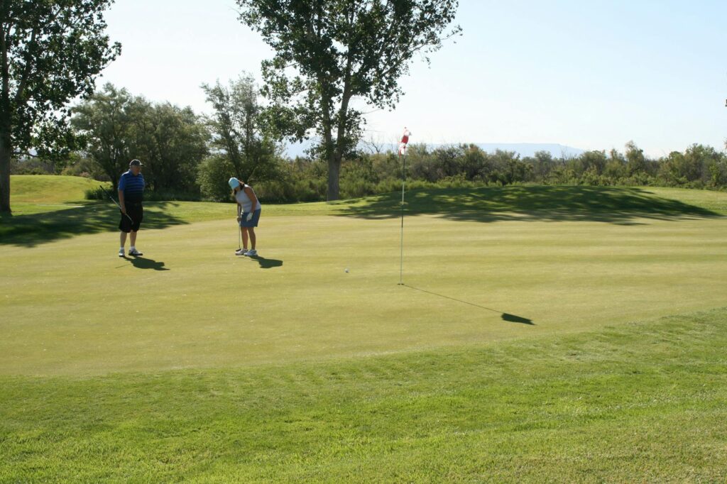 Golfers enjoying a sunny day on the fairway with scenic Dungeness backdrop. — golf courses in Dungeness