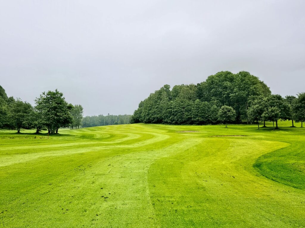 Image of a golf course under cloudy skies, showing potential weather changes. — golf swing changeable weather