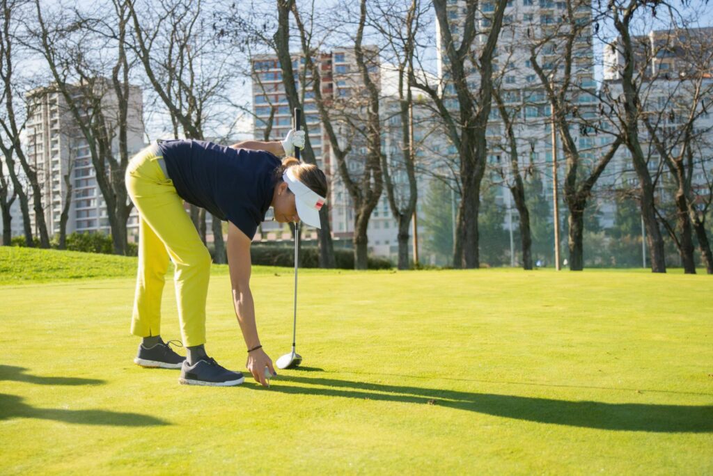 A beginner golfer inspecting a golf driver for wear and tear. — maintain golf driver beginners