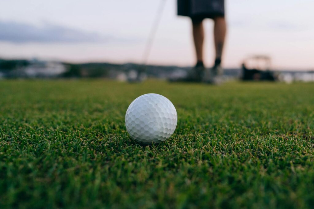 A close-up of a golf ball on the green with a beautiful sunset in the background — best golf courses in Europe