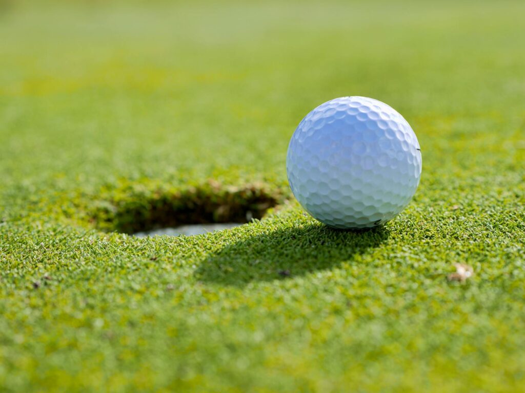 A close-up shot of a golf ball on the green with Dungeness course in the background. — Dungeness golf course membership