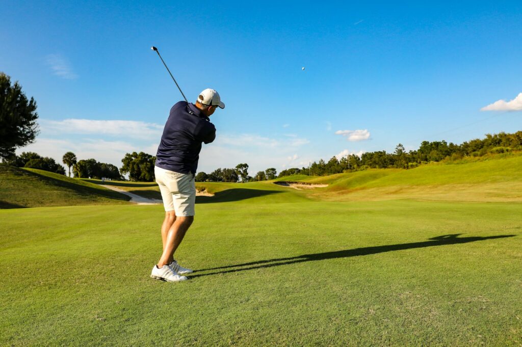 A golfer taking a swing on a lush, green fairway in Florida. — best golf courses in Florida