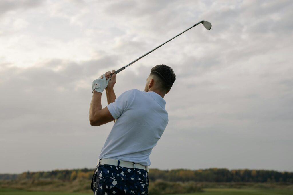 A golfer using a tech gadget that tracks their swing on the course. — golf driver accessories 2026