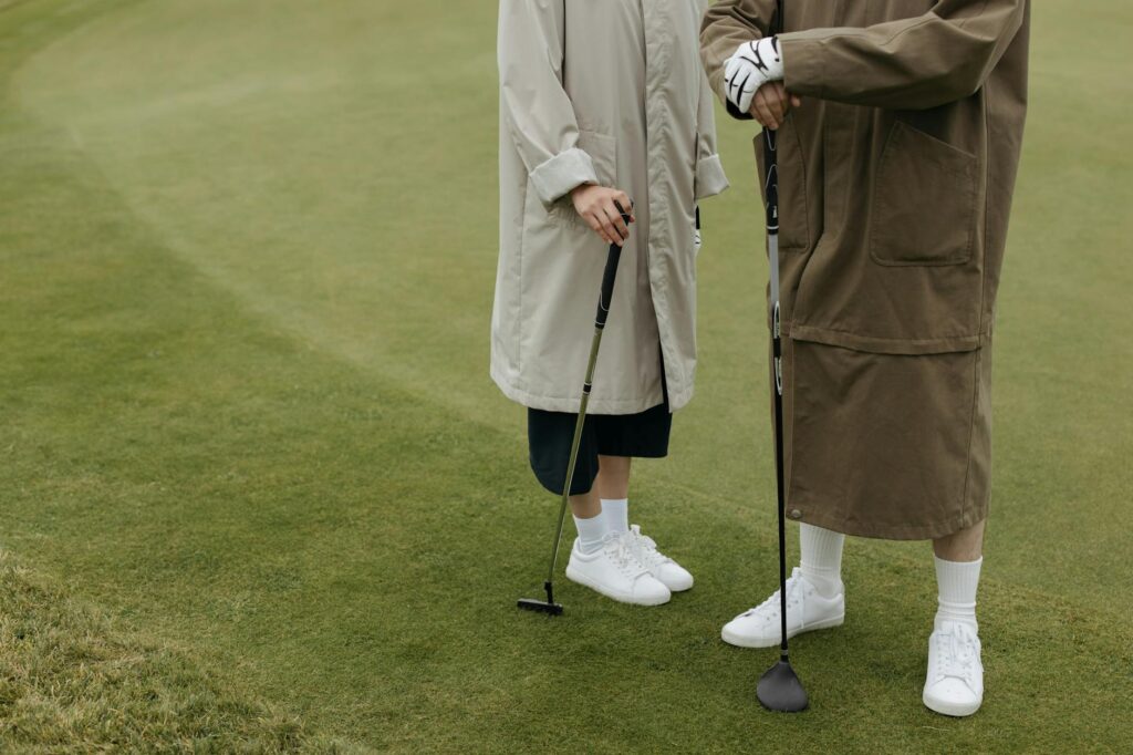A golfer wearing a windbreaker and appropriate footwear on the course. — golf equipment Dungeness
