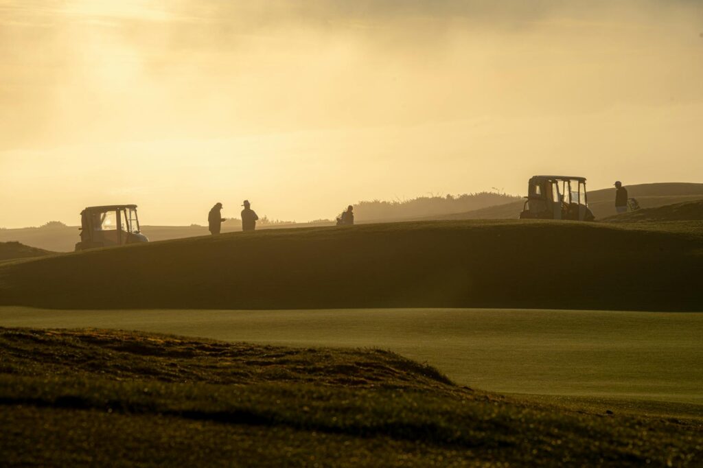 A historical photograph of early golfers playing in Dungeness, showcasing the rich history of golf Dungeness
