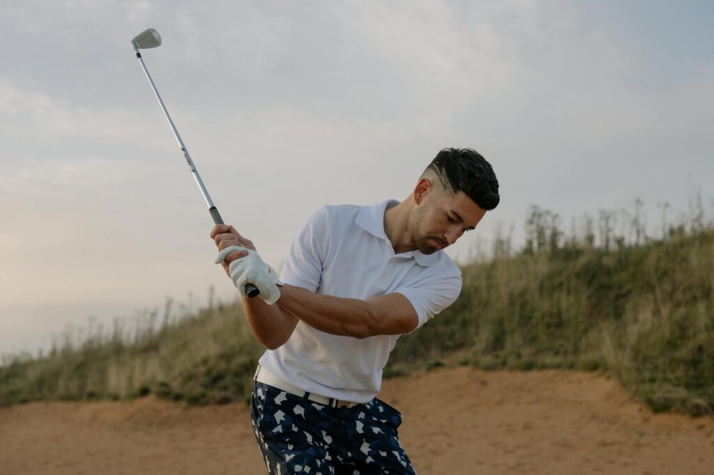 Close-up of a golfer teeing off against a backdrop of Dungeness landscapes — scenic golf holes Dungeness
