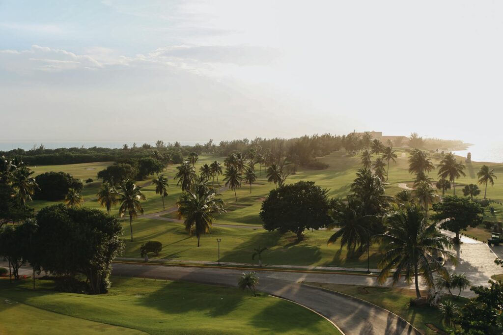 Stunning view of a golf course in Thailand with palm trees and ocean in the background — best golf courses in Asia