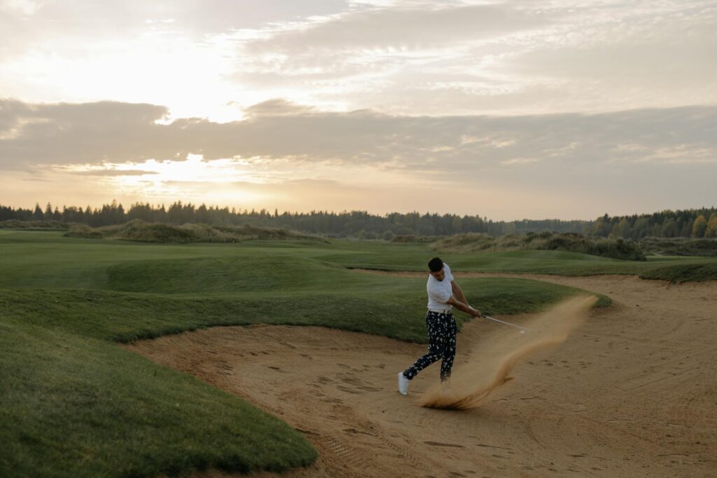 A close-up shot of a golfer in a bunker preparing for a shot, demonstrating proper stance. — short game golf skills