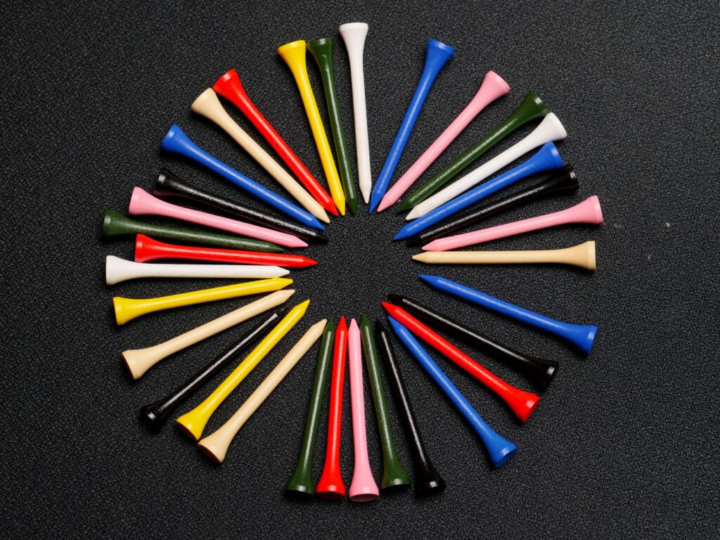A collection of different types of golf tees displayed on a wooden table. — golf accessories