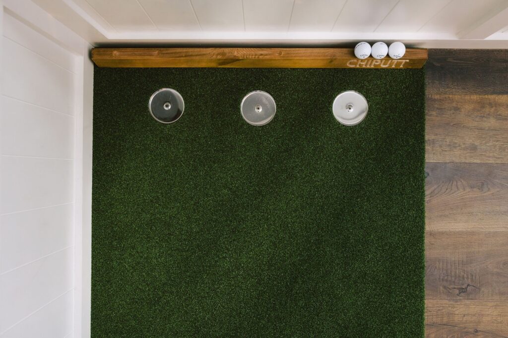 A golfer demonstrating a putting drill on the green. — read golf greens