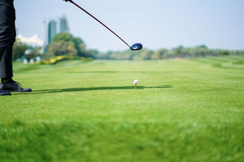 A golfer enjoying a sunny day on the Dungeness course during summer, highlighting the lush greens. — best time to play D…