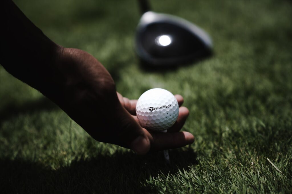 A close-up shot of the TaylorMade SIM2 Max Hybrid on a tee. — best golf hybrids