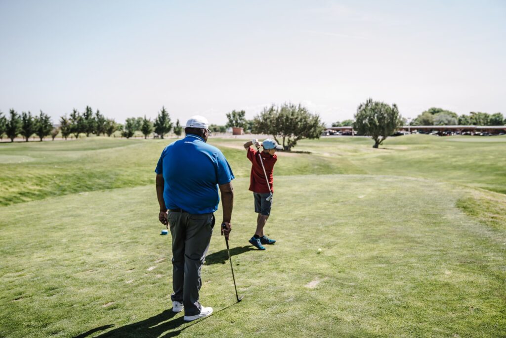 A golfer teeing off on a sunny summer day at Dungeness. — best time to play golf Dungeness