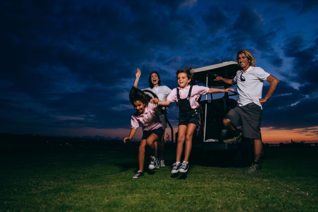 A smiling family posing together on the golf course, capturing a memorable moment. — family golf activities Dungeness