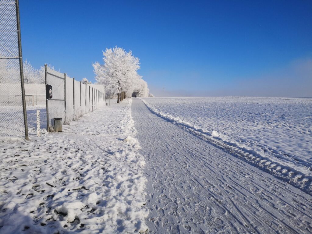 A winter scene showing the Dungeness course covered in frost. — best time to play golf Dungeness