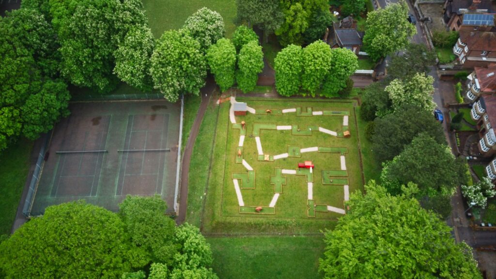 An aerial shot comparing the layout of a public and a private golf course, showcasing the differences in facilities and accessibility between public vs private golf courses Dungeness.