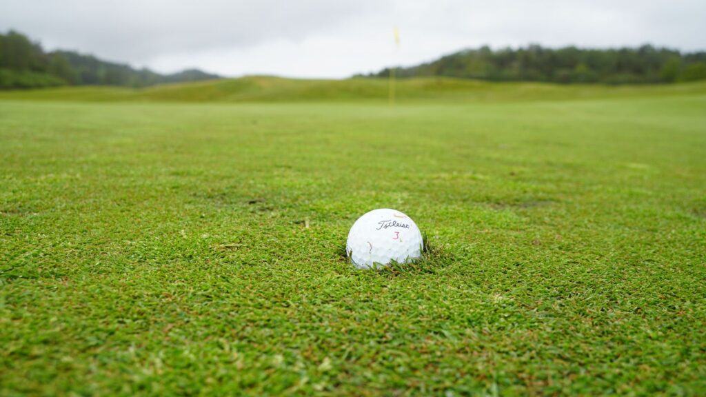 Close-up of a wet golf ball on a rainy course. — golf in rain tips