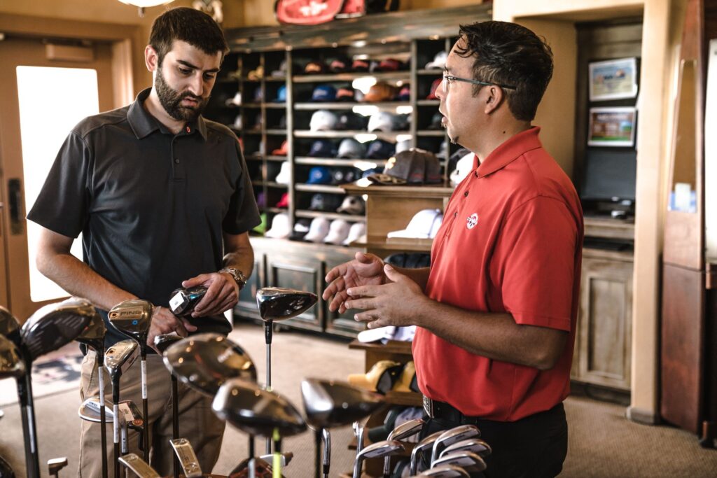 A beginner golfer selecting clubs at a local Dungeness pro shop — choosing golf clubs Dungeness