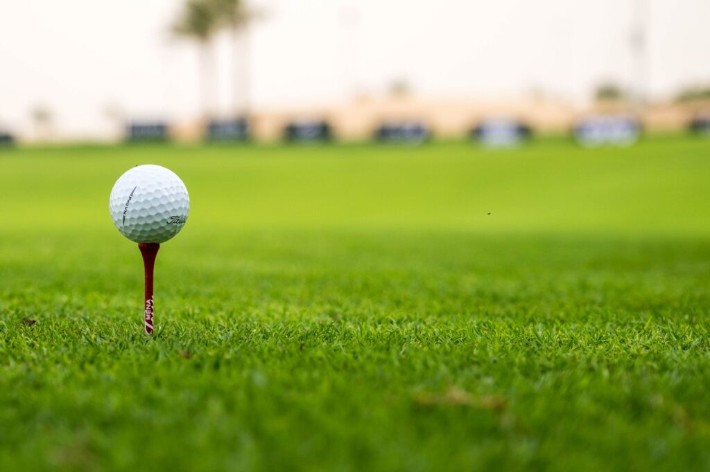 A close-up of a golf ball on a tee, ready for a shot in Dungeness — Dungeness golf tournaments