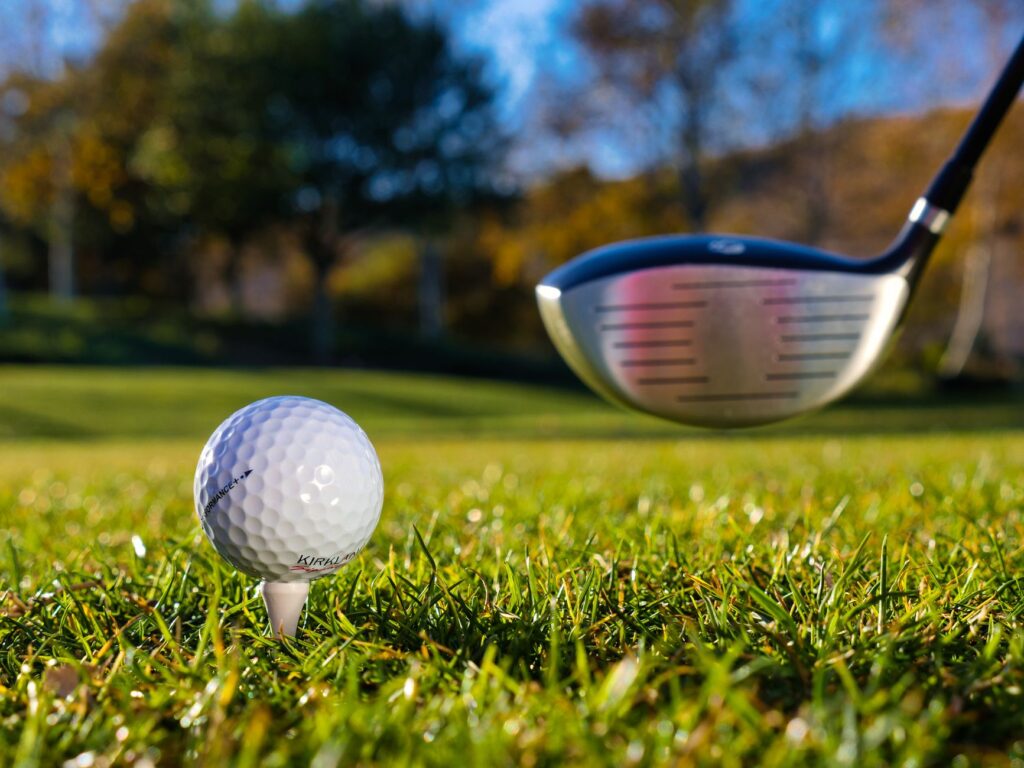 A close-up of a golf ball on a tee with a picturesque course in the distance. — golf courses near Dungeness