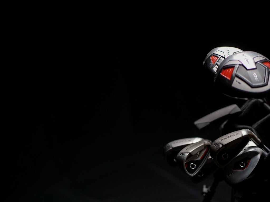 A close-up of vibrant fall leaves with golf clubs in the foreground. — Dungeness golf fall 2026