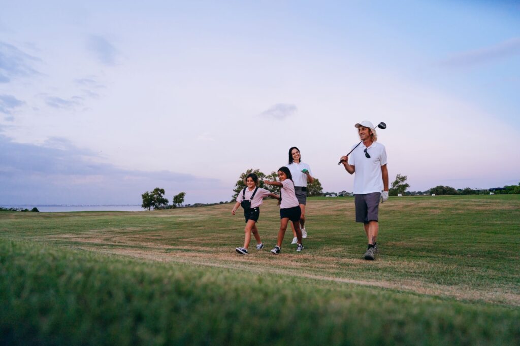 A family playing golf at Dungeness Golf Course with children smiling. — family golf Dungeness