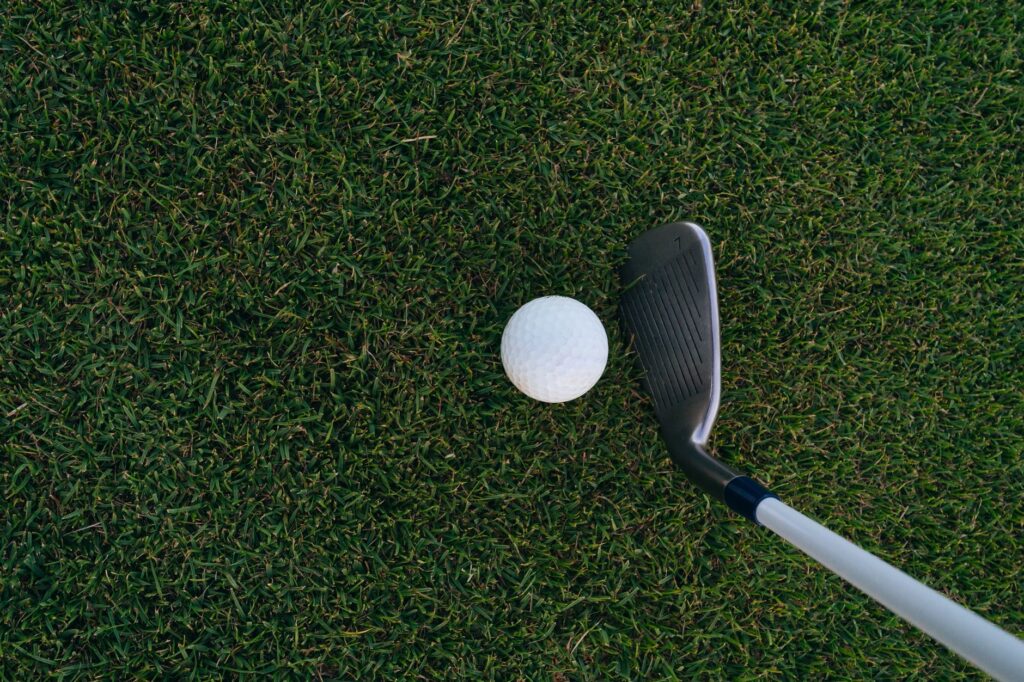 A golf club making contact with the ball on the course, showcasing efforts to improve golf swing Dungeness.