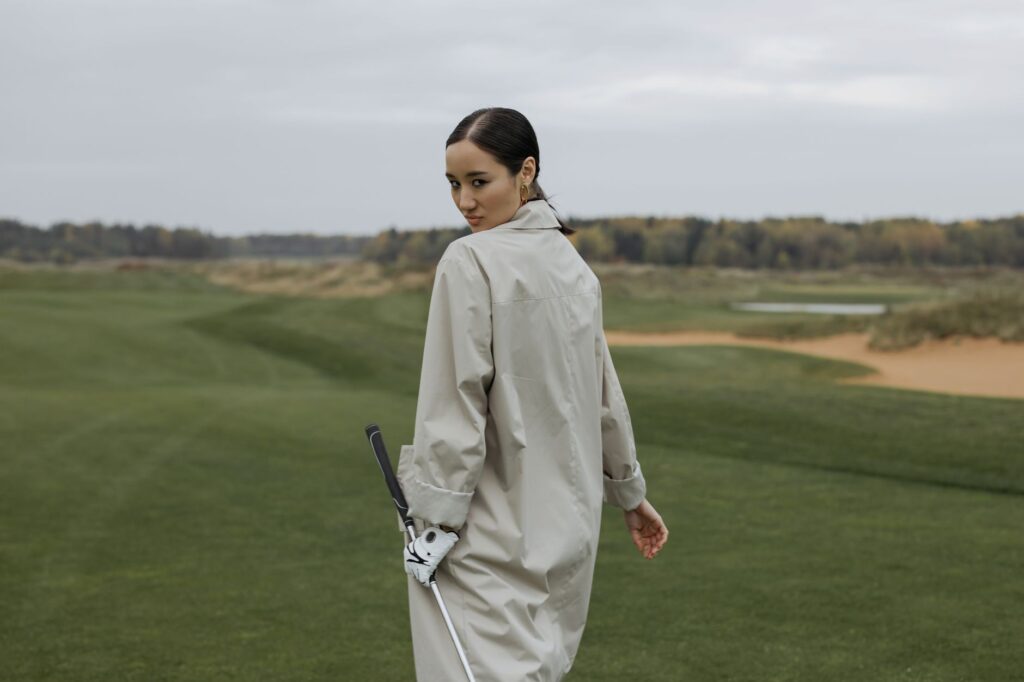A golfer dressed appropriately for fall weather, with layers and a light jacket. — golfing Dungeness fall benefits