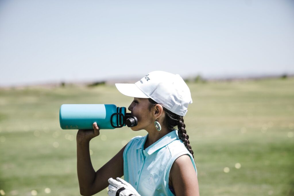 A golfer enjoying snacks and hydration on the course. — golf packing list Dungeness
