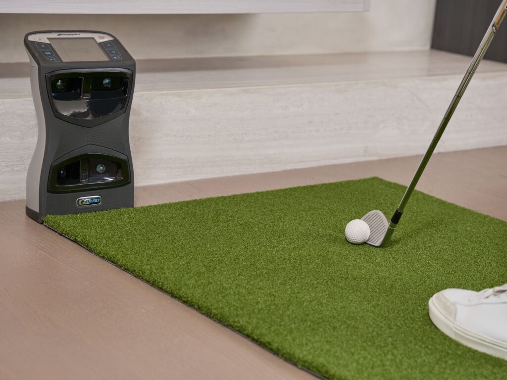 A golfer using a simulator to practice their swing with a focus on the screen displaying their stats. — golf simulator s…