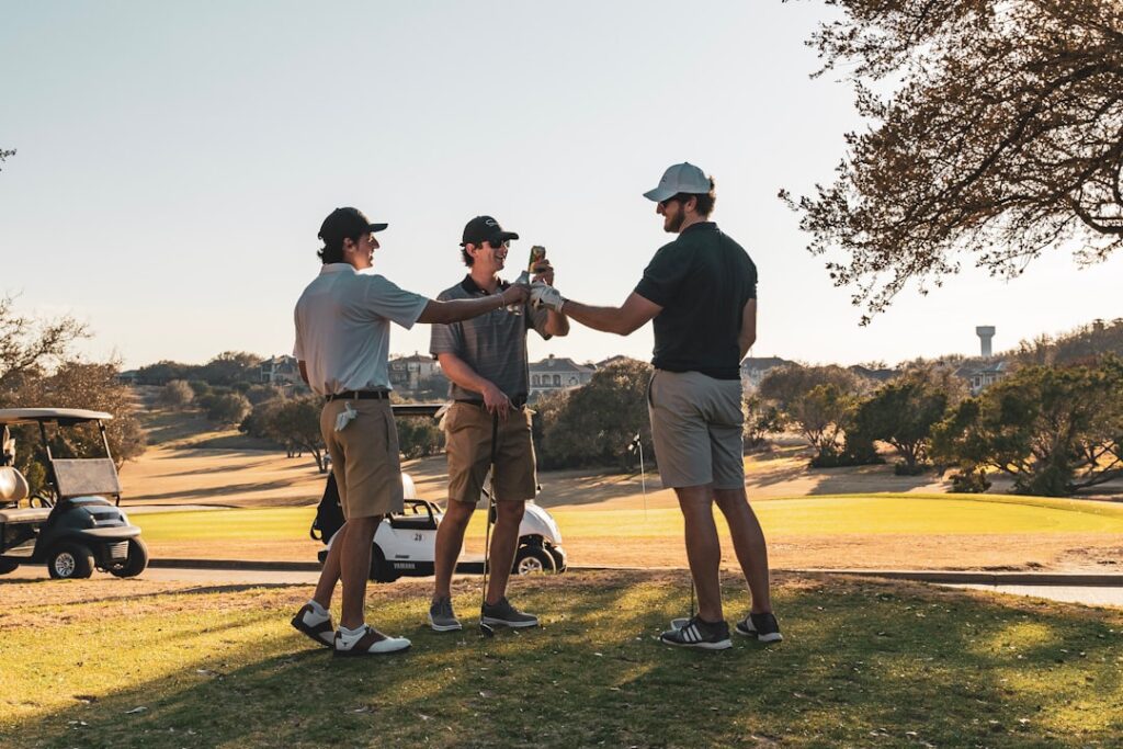 A group of golfers engaging in friendly conversation on the course, demonstrating camaraderie. — golfing etiquette Dunge…