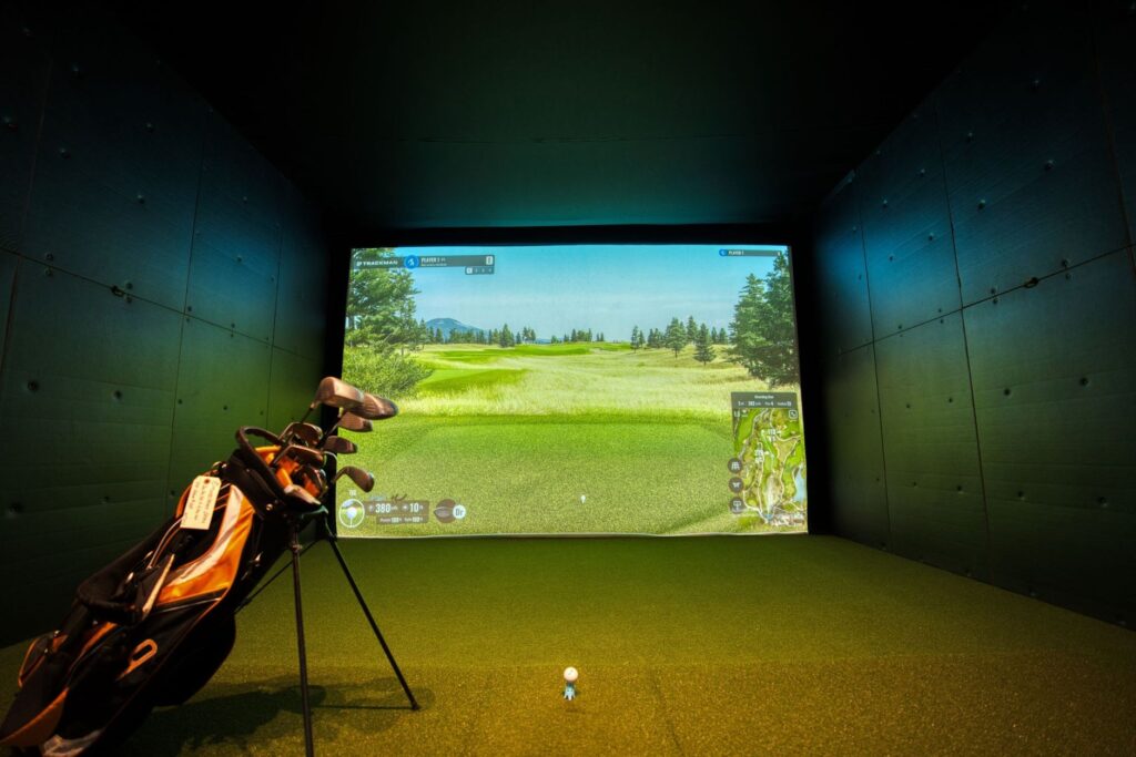 A high-end golf simulator setup in a home environment with a large screen and realistic graphics. — golf simulator systems