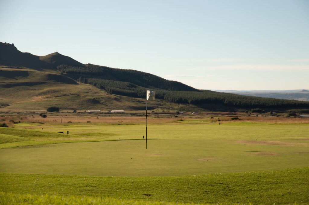 A scenic view of a golf course at Dungeness with rolling hills in the background — golf trip to Dungeness