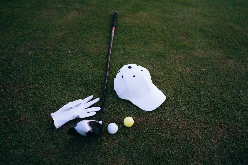 An array of golf accessories Dungeness like tees, gloves, and rangefinders laid out on a table. — golf gear Dungeness