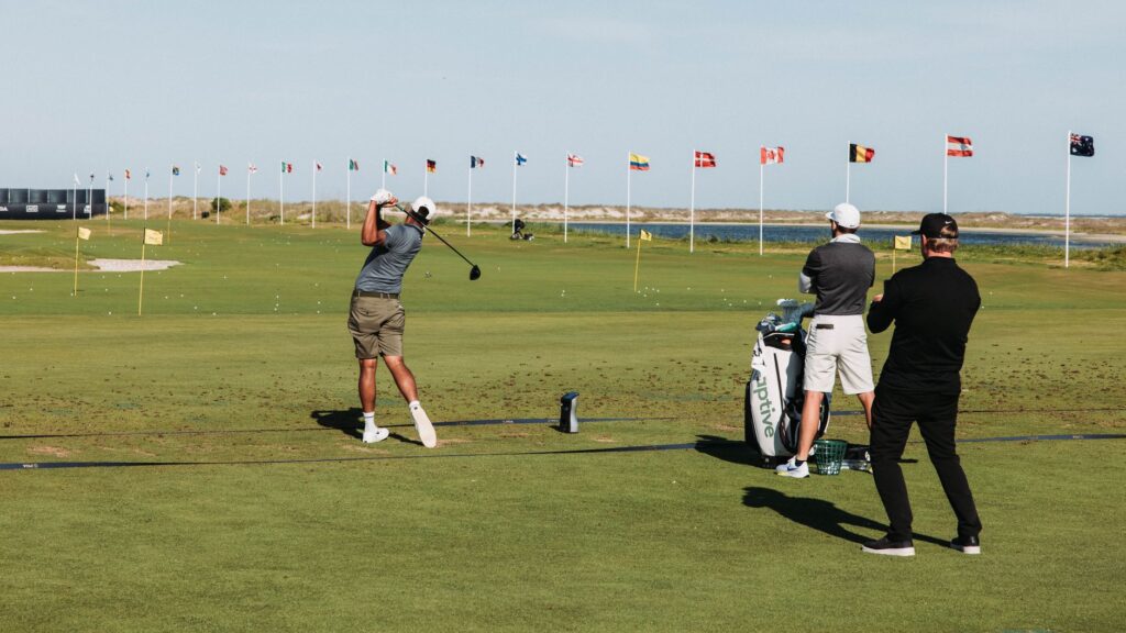 Golfers practicing their swings on a sunny Dungeness course — summer golfing tips Dungeness