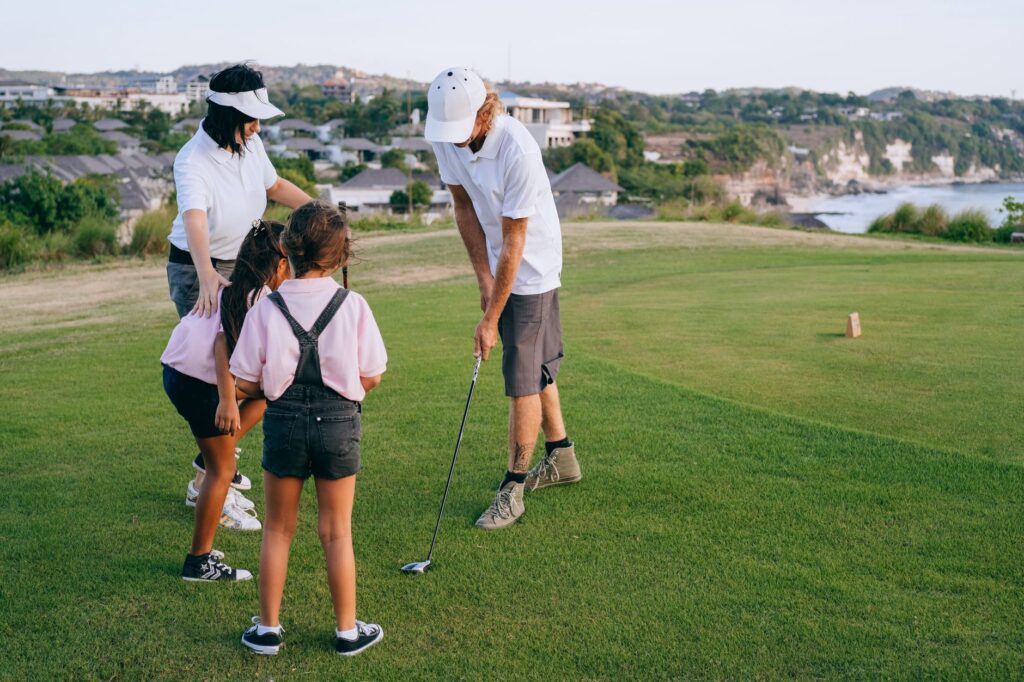 Parents teaching their kids how to putt on the green — family golf Dungeness