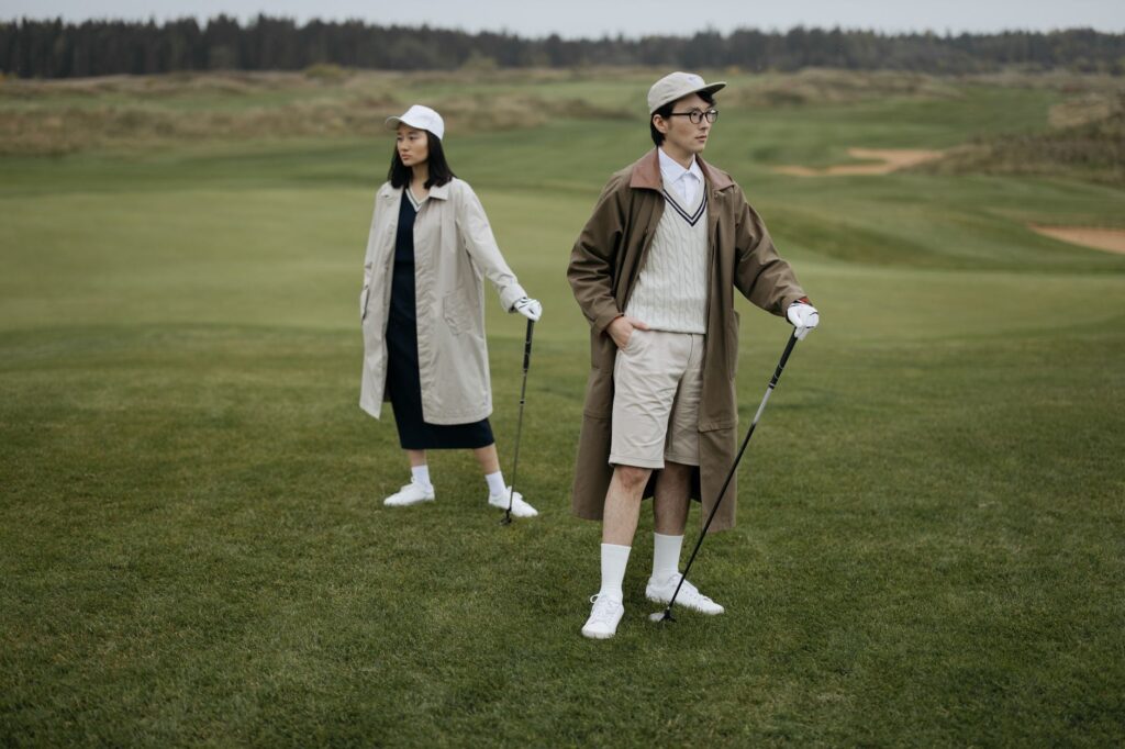 A golfer adjusting his cap against strong winds on the course — weather impact on Dungeness golf